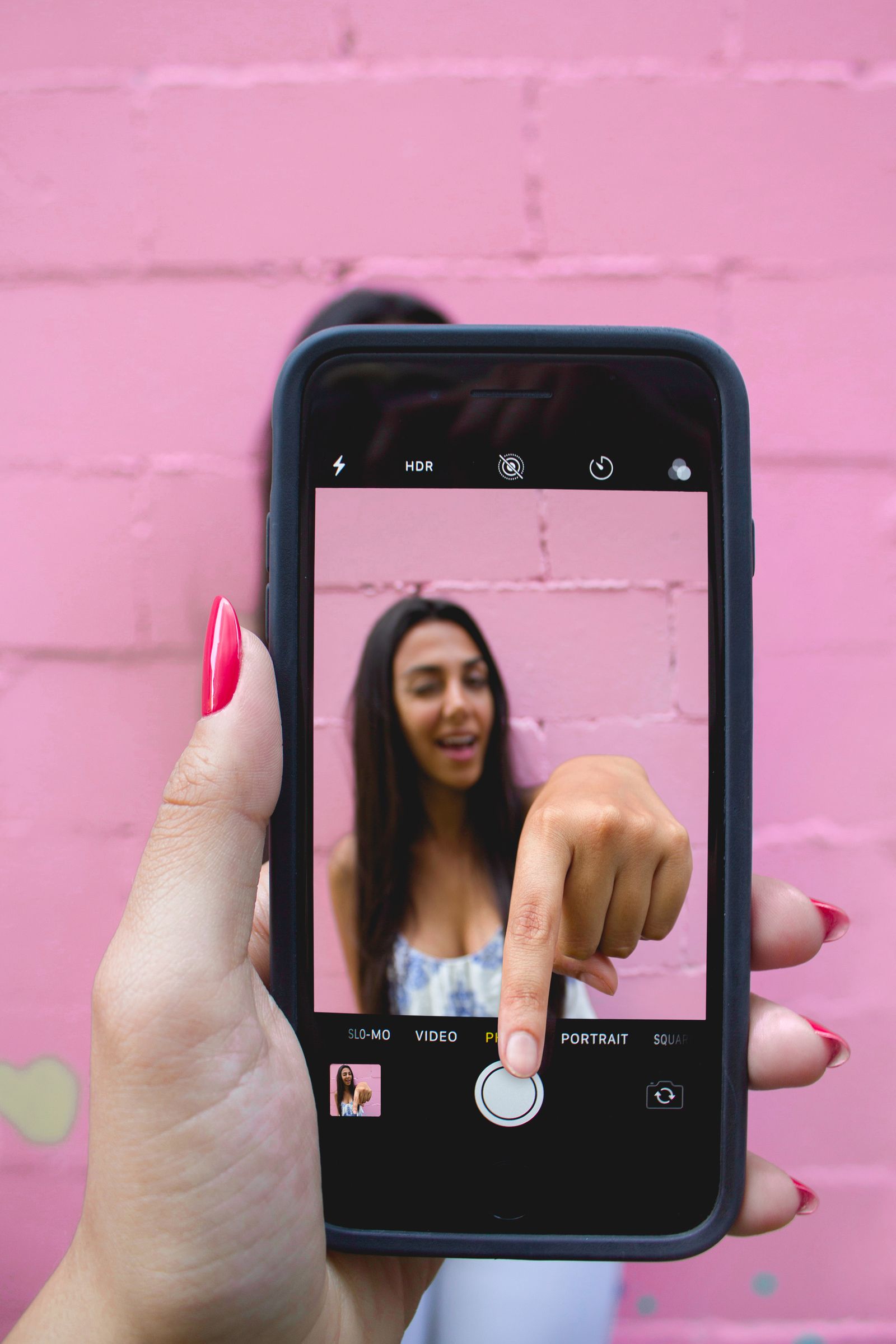 Person capturing a face selfie on a smartphone