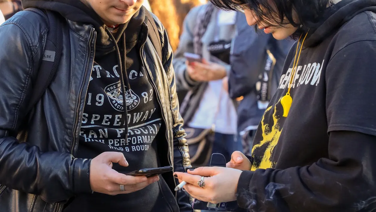 Group of young people with phones and laptops