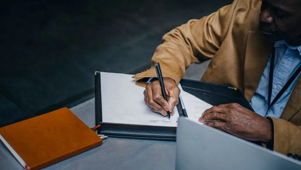 Developer writing a test plan next to a laptop